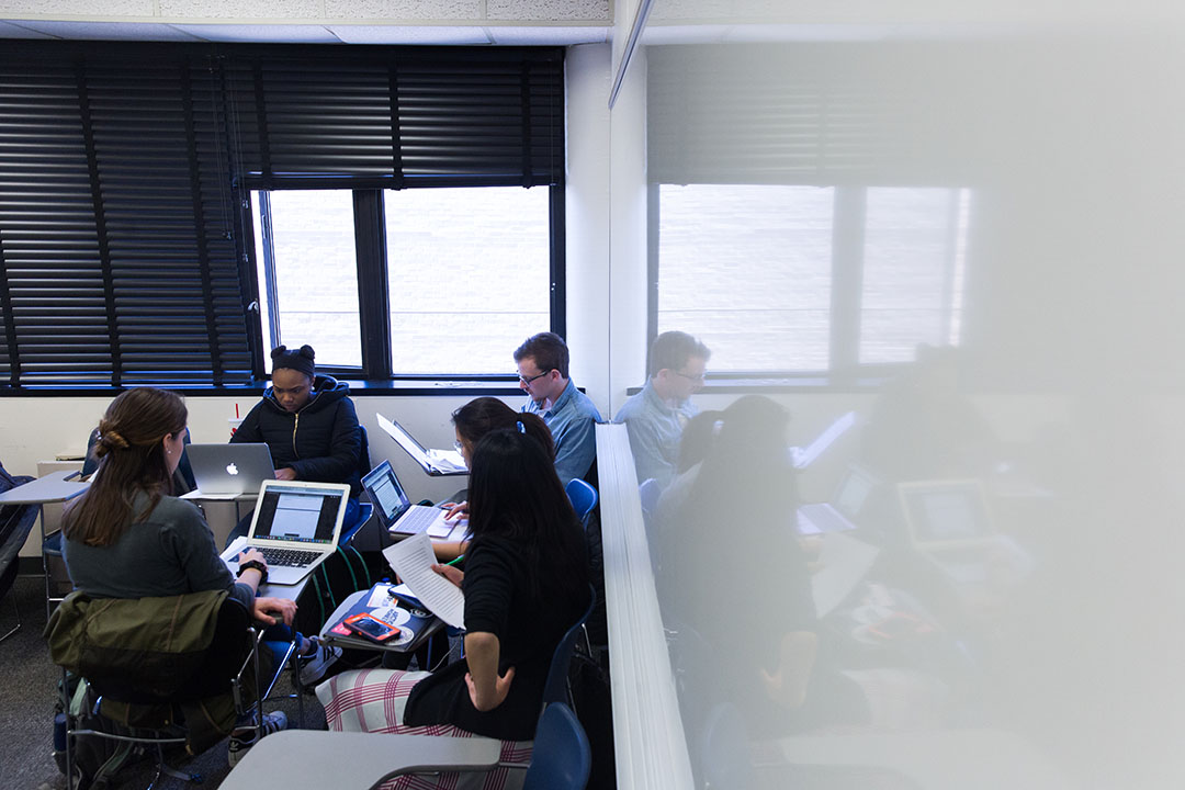 Students at desks in an English class with a large whiteboard