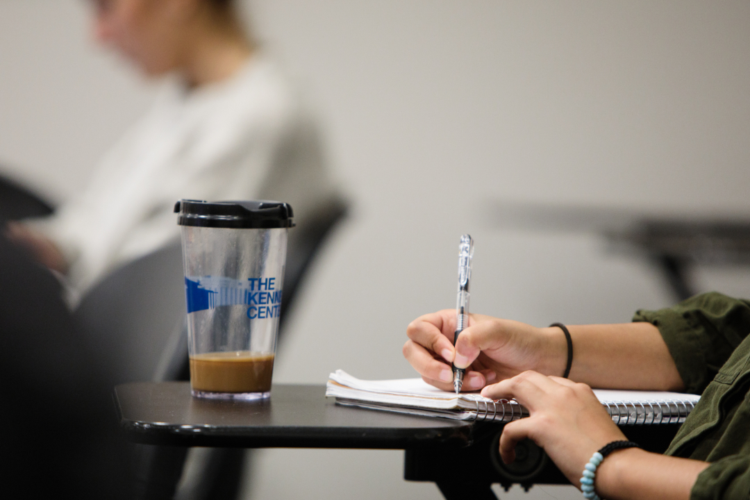 A student's hand writing in a notebook