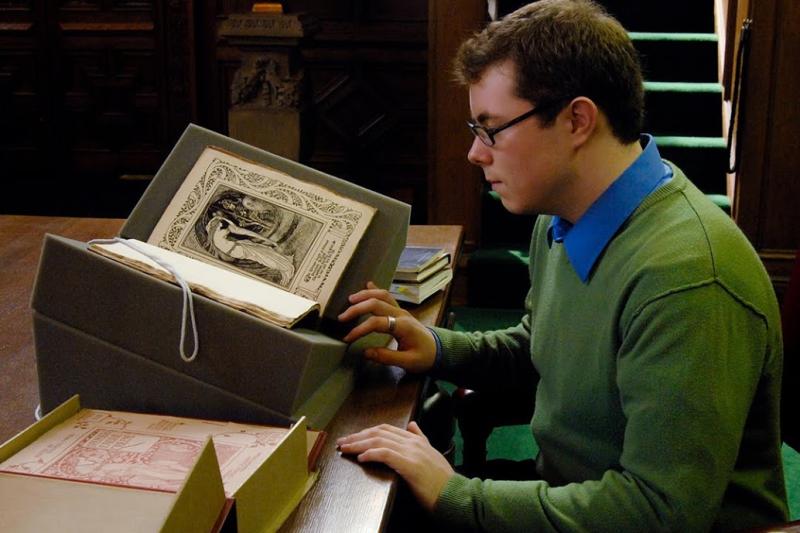 Student reading an old Shakespeare folio in an archive setting